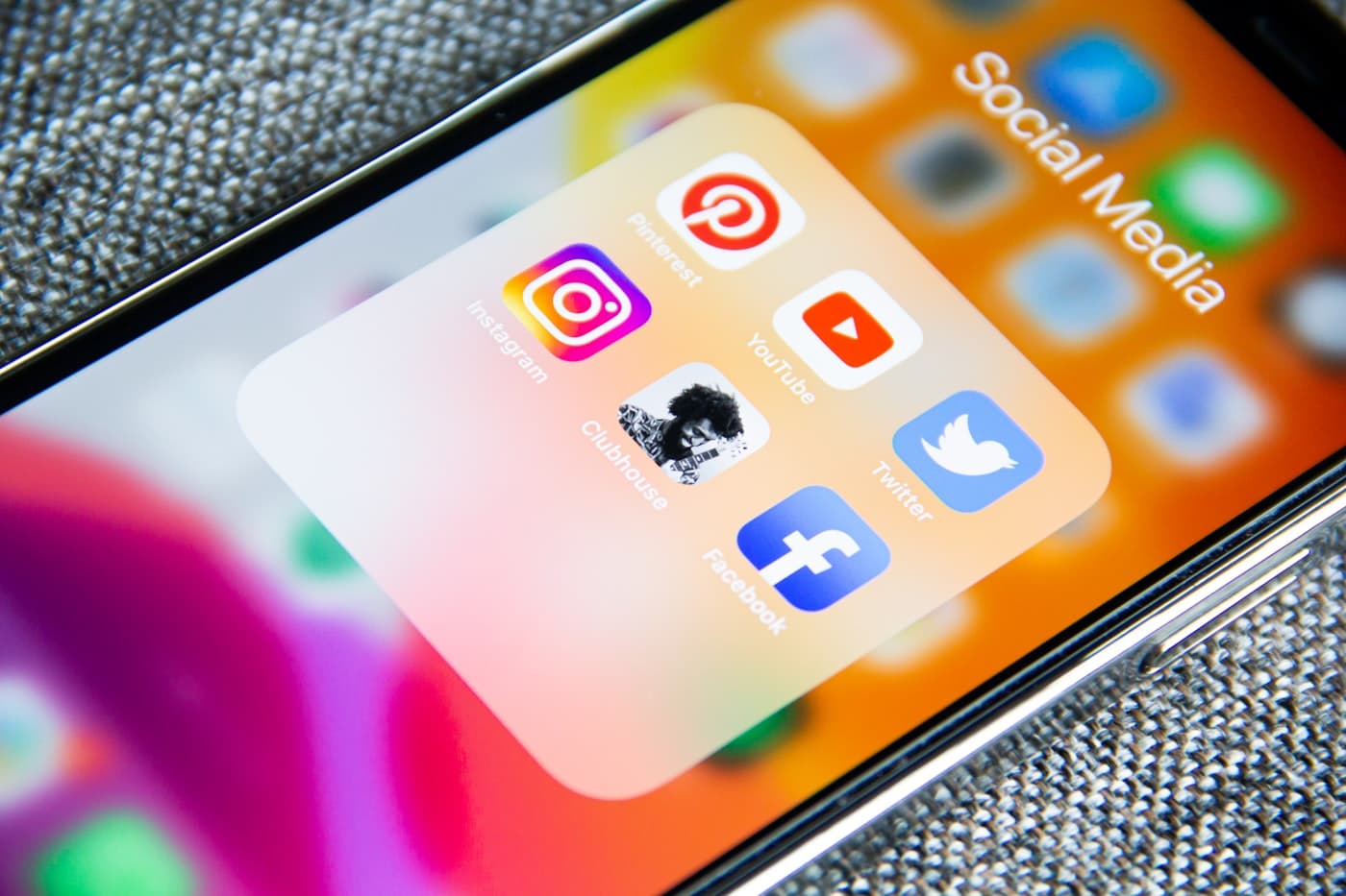 A close-up of a phone home screen with major social media app icons.